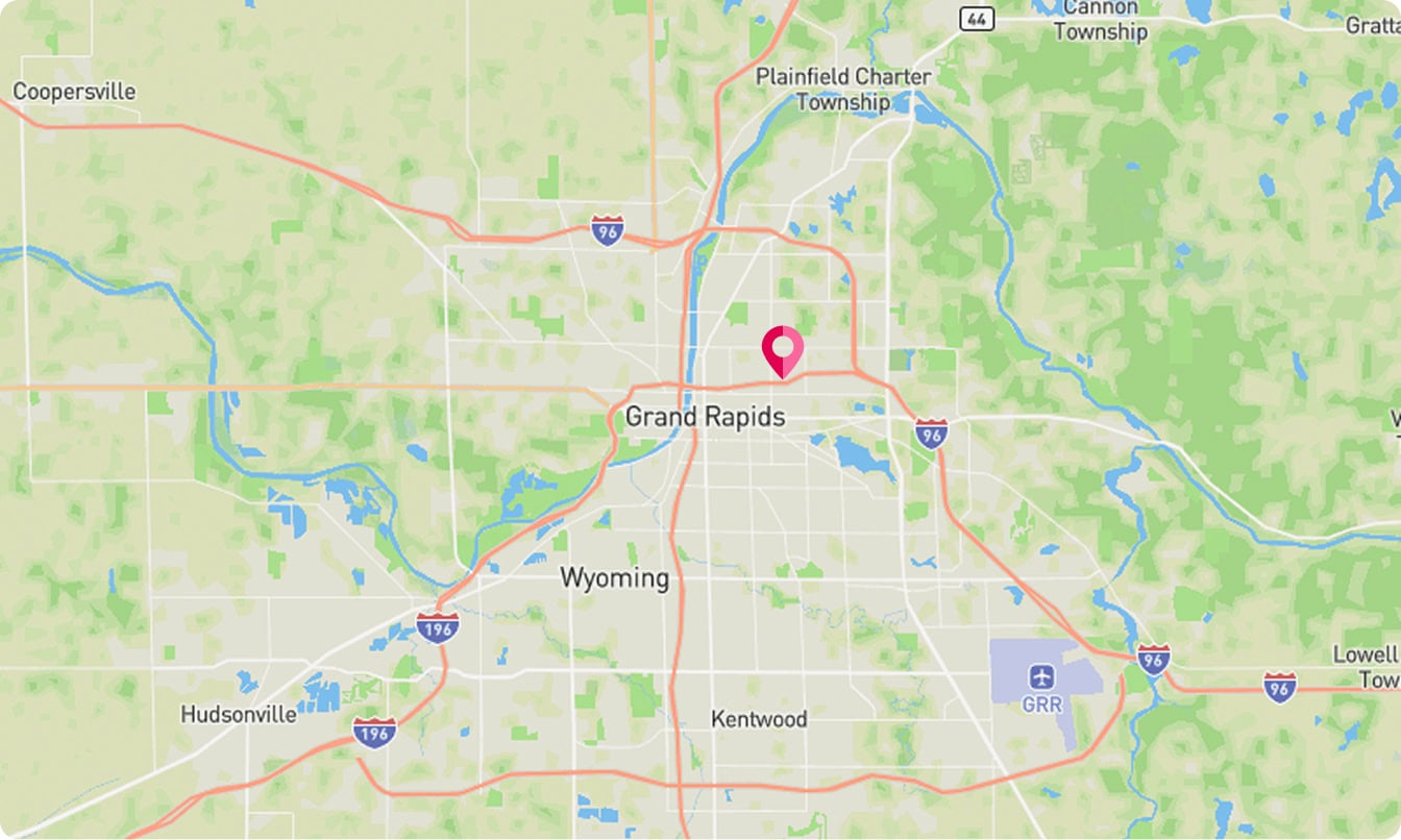 Map of Grand Rapids, Michigan, and surrounding areas with a pink location marker in the central part of Grand Rapids. Major roads, towns, and green spaces are visible.